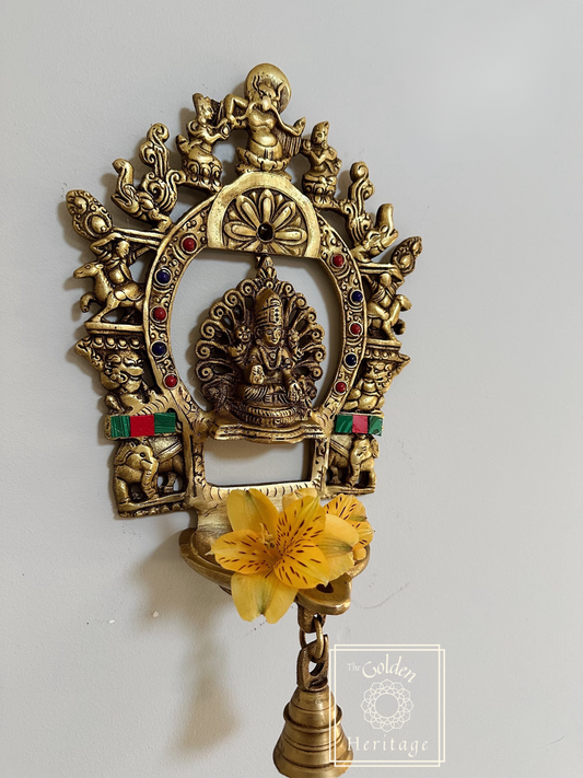 A brass hanging Sukhasana Laxmi figure with a Prabhavali and Diya, featuring intricate designs.