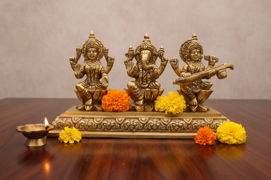 A brass Hindu deity triad statues Ganesha, Laxmi & Saraswati  on an ornate rectangular base