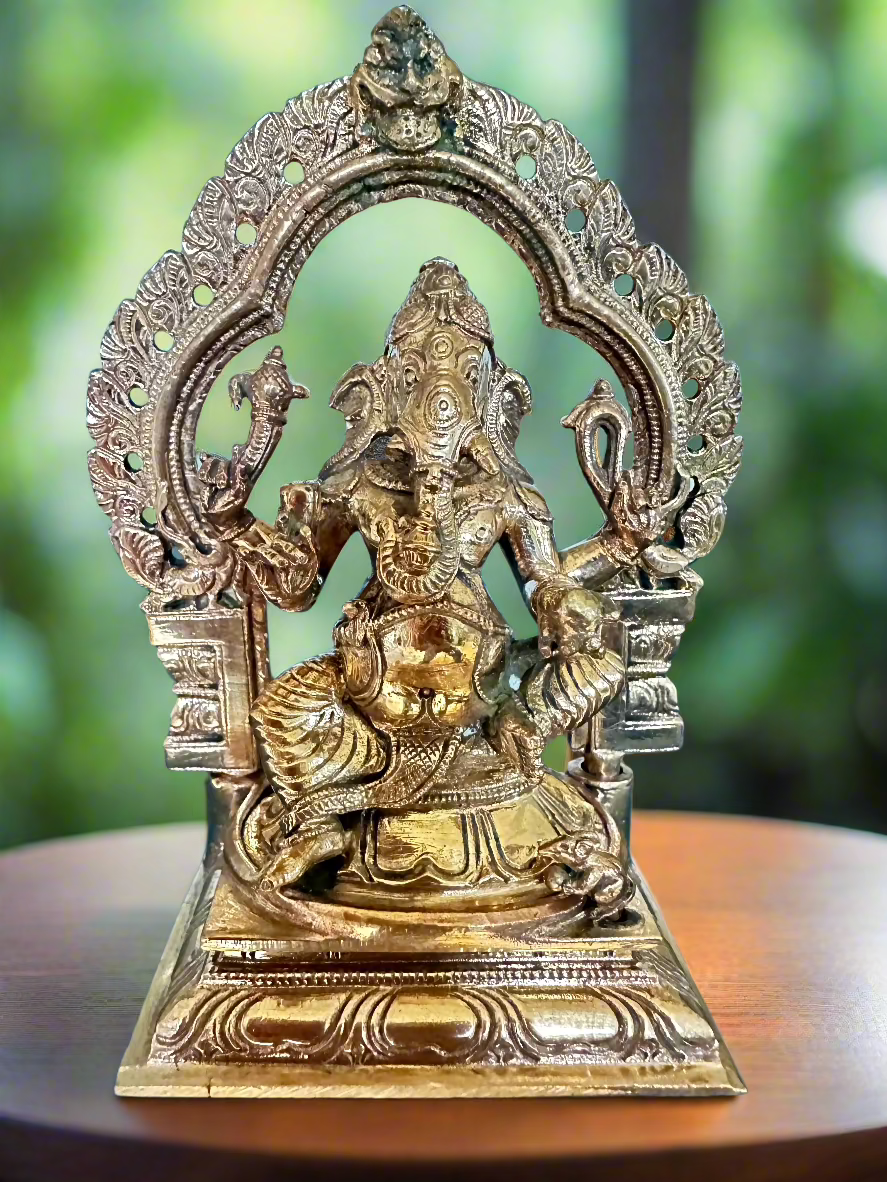 A bronze statue of Ganesha, the Hindu god, sitting on a throne 