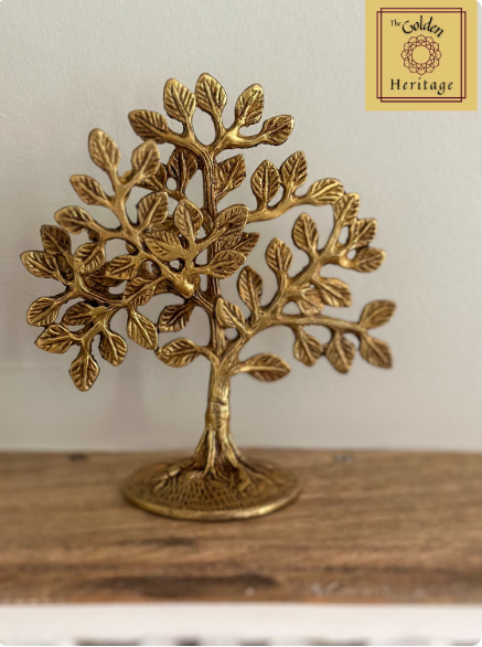 A brass statue of a Bodhi Tree with intricate details, placed on a wooden surface.