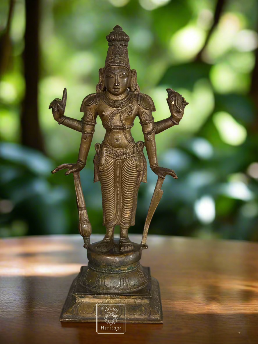 Bronze idol of Lord Vishnu with multiple arms extended, standing on a square base, with a conch shell, chakra, and lotus flower.