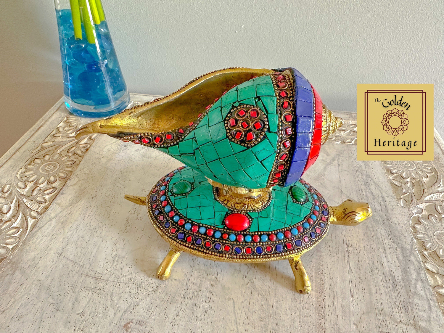 A handcrafted brass conch with turtle, adorned with colorful stones.